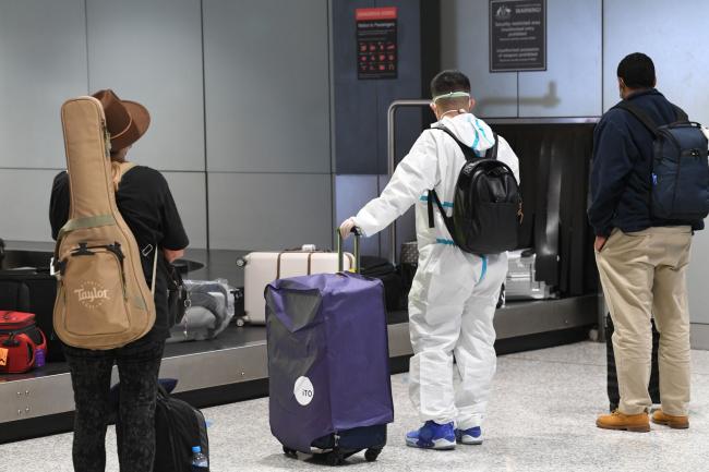 © Bloomberg. SYDNEY, AUSTRALIA - JULY 29: Passengers from a Qantas flight arriving into Sydney Airport from Brisbane, Queensland on July 29, 2021 in Sydney, Australia. Lockdown restrictions in NSW continue as the state continues to record new community COVID-19 cases and work to stop the spread of the highly infectious delta coronavirus strain in the community. New rules which came into effect at midnight on Saturday across Greater Sydney including the Central Coast, Blue Mountains, Wollongong and Shellharbour require all non-essential retail to close. Businesses can still operate click and collect, takeaway and home delivery. In addition to stay at home orders, residents in the local government areas of Fairfield, Canterbury-Bankstown and Liverpool cannot leave their areas for work except for emergency services and healthcare workers. Where those workers do need to leave their local government area for work, they are required to be tested every three days, even if they do not have symptoms. Residents of Greater Sydney, the Blue Mountains, the Central Coast and Wollongong are subject to stay-at-home orders with people are only permitted to leave their homes for essential reasons. Essential reasons include purchasing essential goods, accessing or providing care or healthcare, essential work, education or exercise. Exercise is restricted to within the local government area and no further than 10km from home and with a maximum of two people per group. Browsing in shops is prohibited and only one person per household can leave home for shopping per day. Outdoor public gatherings are limited to two people, while funerals are limited to 10 people only. (Photo by James D. Morgan/Getty Images) Photographer: James D. Morgan/Getty Images AsiaPac