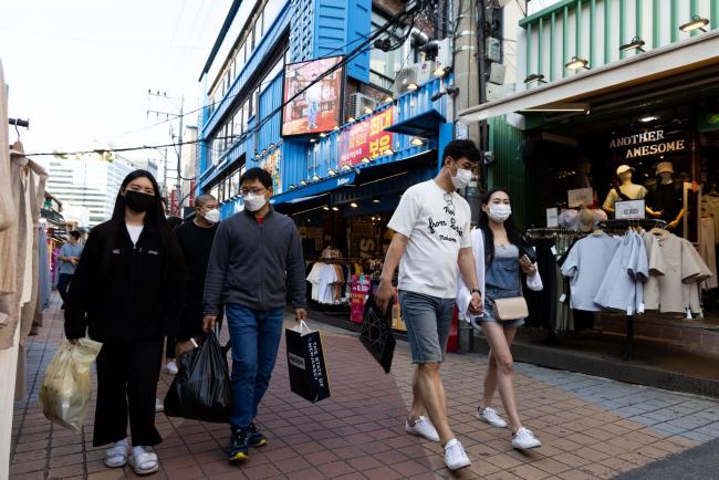 © Bloomberg. Shoppers wearing protective masks walk through the Hongdae shopping district in Seoul, South Korea, on Saturday, May 22, 2021. South Korea is scheduled to release consumer confidence figures on May 25.