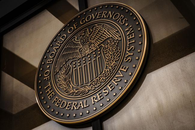 © Bloomberg. The seal of the U.S. Federal Reserve Board of Governors across the street from the Marriner S. Eccles Federal Reserve building in Washington, D.C., U.S., on Sunday, Dec. 19, 2021. The Federal Reserve chair has tempered his ambition to restore the labor market to its pre-pandemic strength, as the central bank confronts surging inflation and a workforce still constrained by Covid-19. Photographer: Samuel Corum/Bloomberg