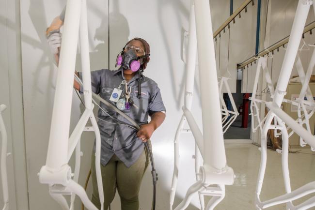 © Bloomberg. A worker coats bicycle frames with powder paint at a production facility in Manning, South Carolina. Photographer: Micah Green/Bloomberg